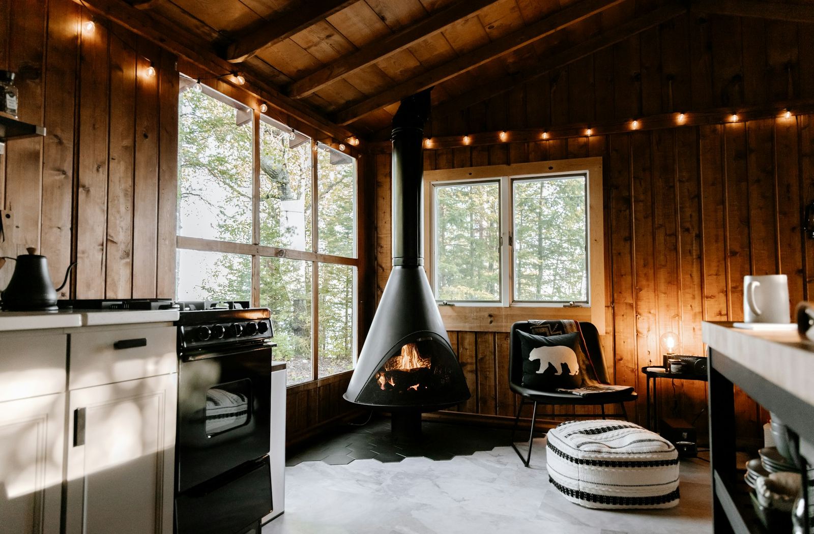 The main room — suspended wood stove and string lights