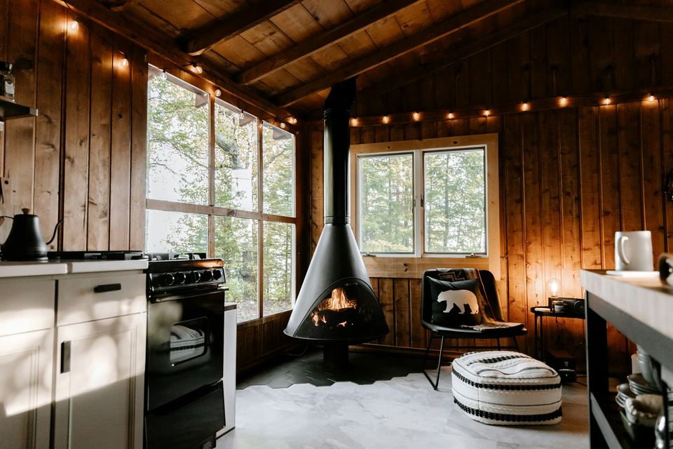 The main room of a cabin with a suspended wood stove