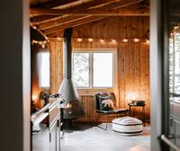 The room seen from the doorway, stove and a reading chair