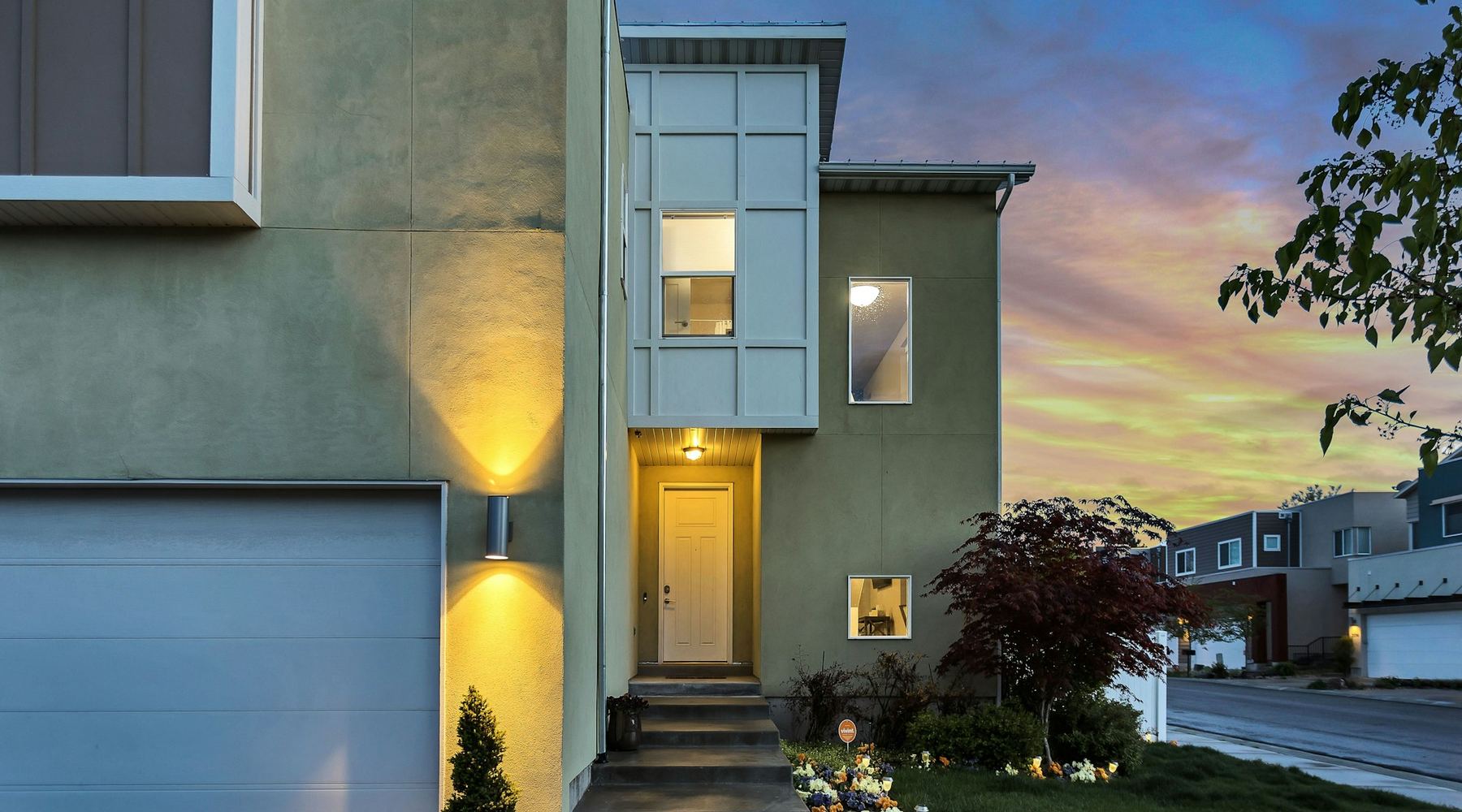 A lit house at dusk, steps up to the front door