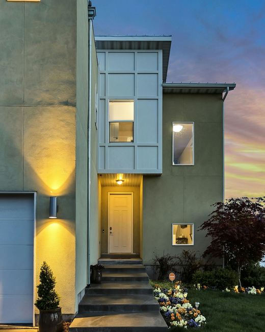 A modern house lit from within at dusk