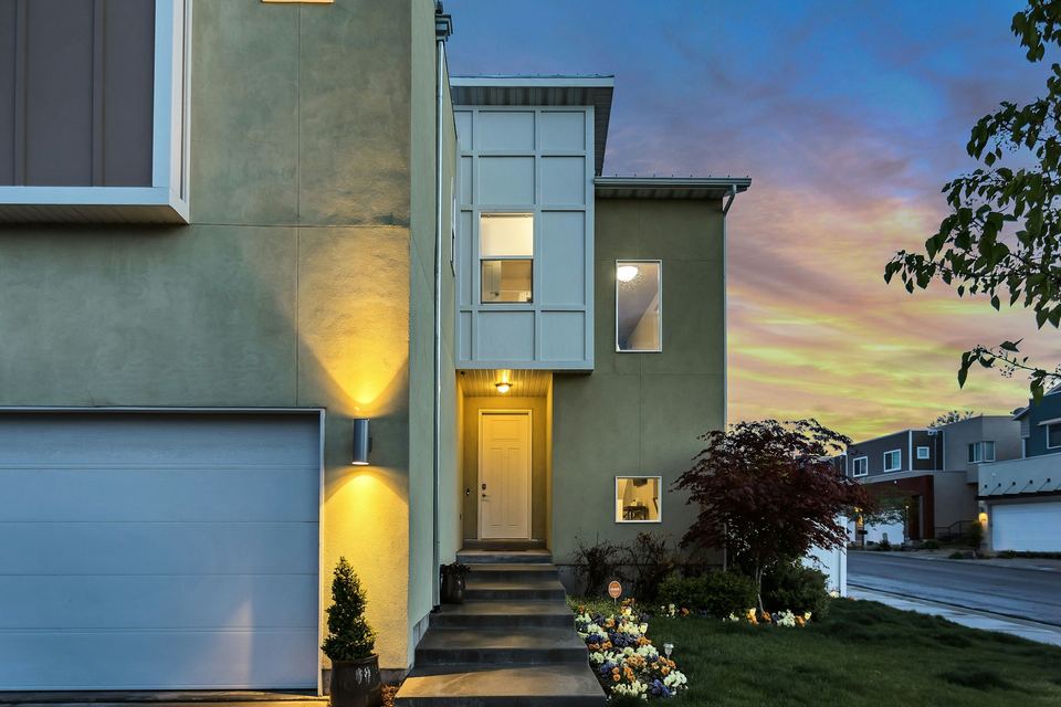 A modern house lit from within at dusk